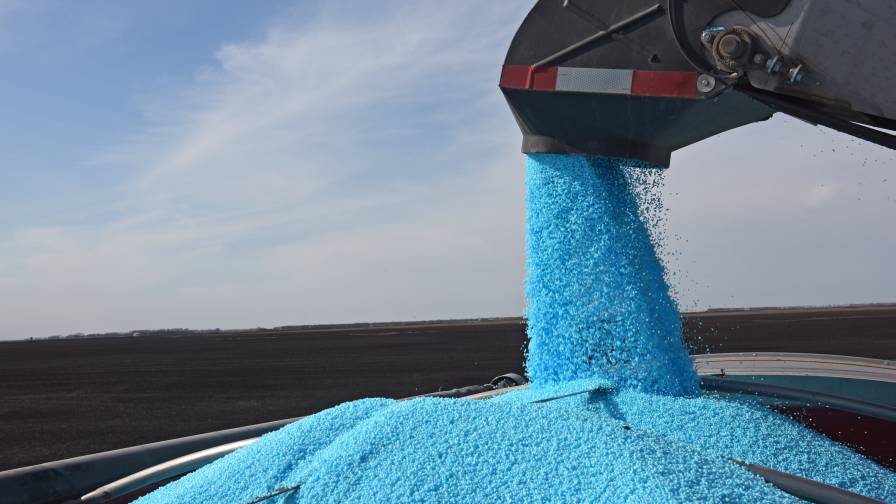 Urea treated with N-Edge Pro nitrogen stabilizer by CHS is shown being loaded into spreader for application. Photo: CHS.